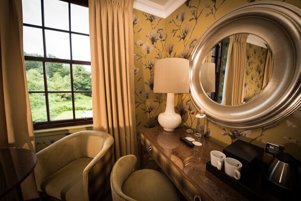A hotel room with a large window, a chair, a bedside table with a lamp, and a mirror. - Gleddoch Golf & Spa Resort, WorldHotels Distinctive (Port Glasgow)