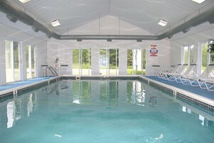Una piscina techada, sillones reclinables de piscina