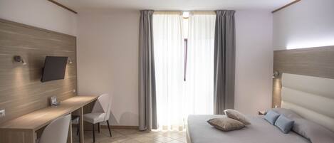 Una habitación de hotel moderna con una cama, un escritorio y una silla.
