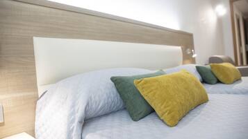 A bed with a wooden headboard and multiple pillows in different colors.