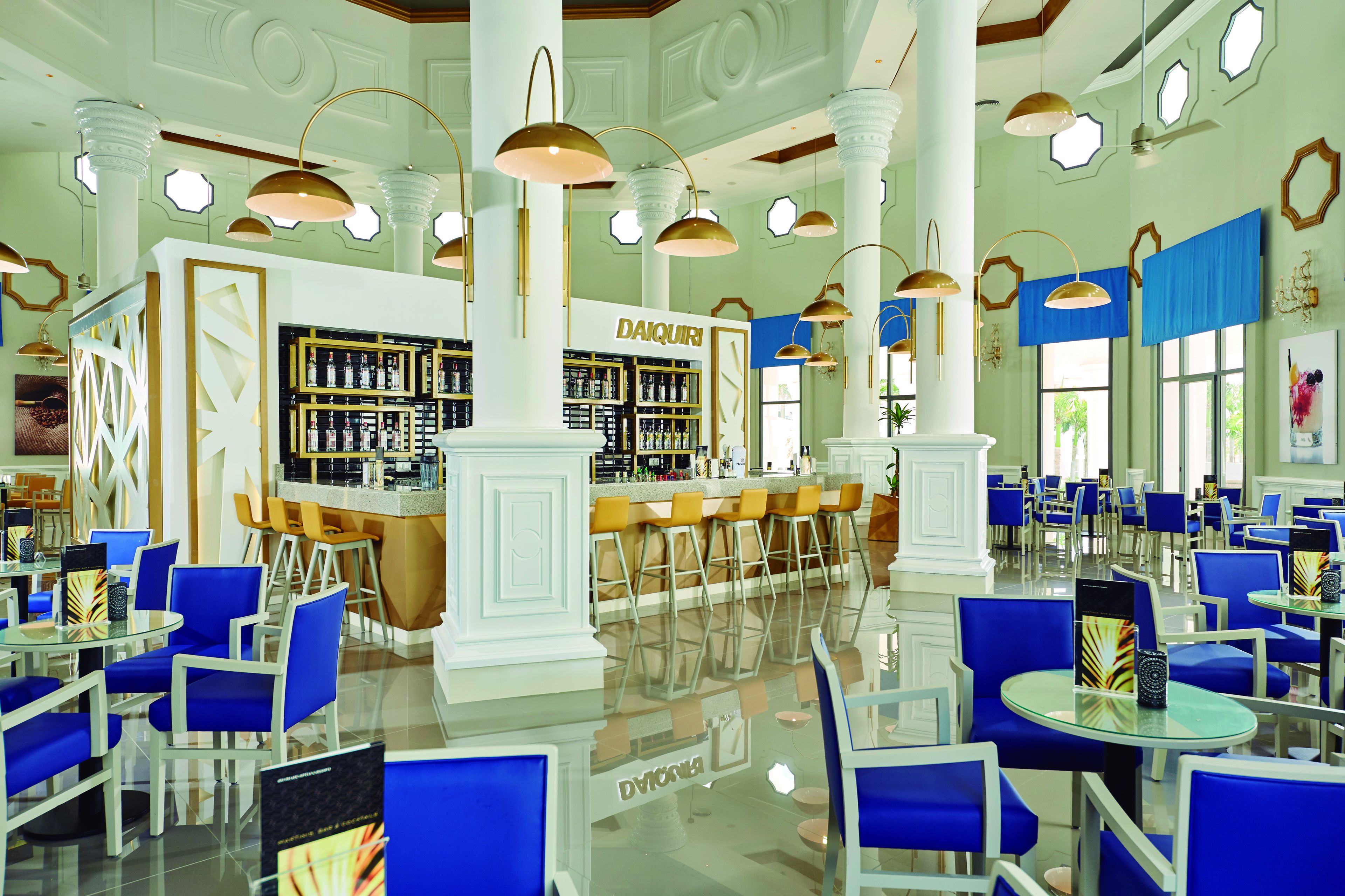 A spacious hotel lobby with a bar area, multiple seating arrangements, and a polished floor.
