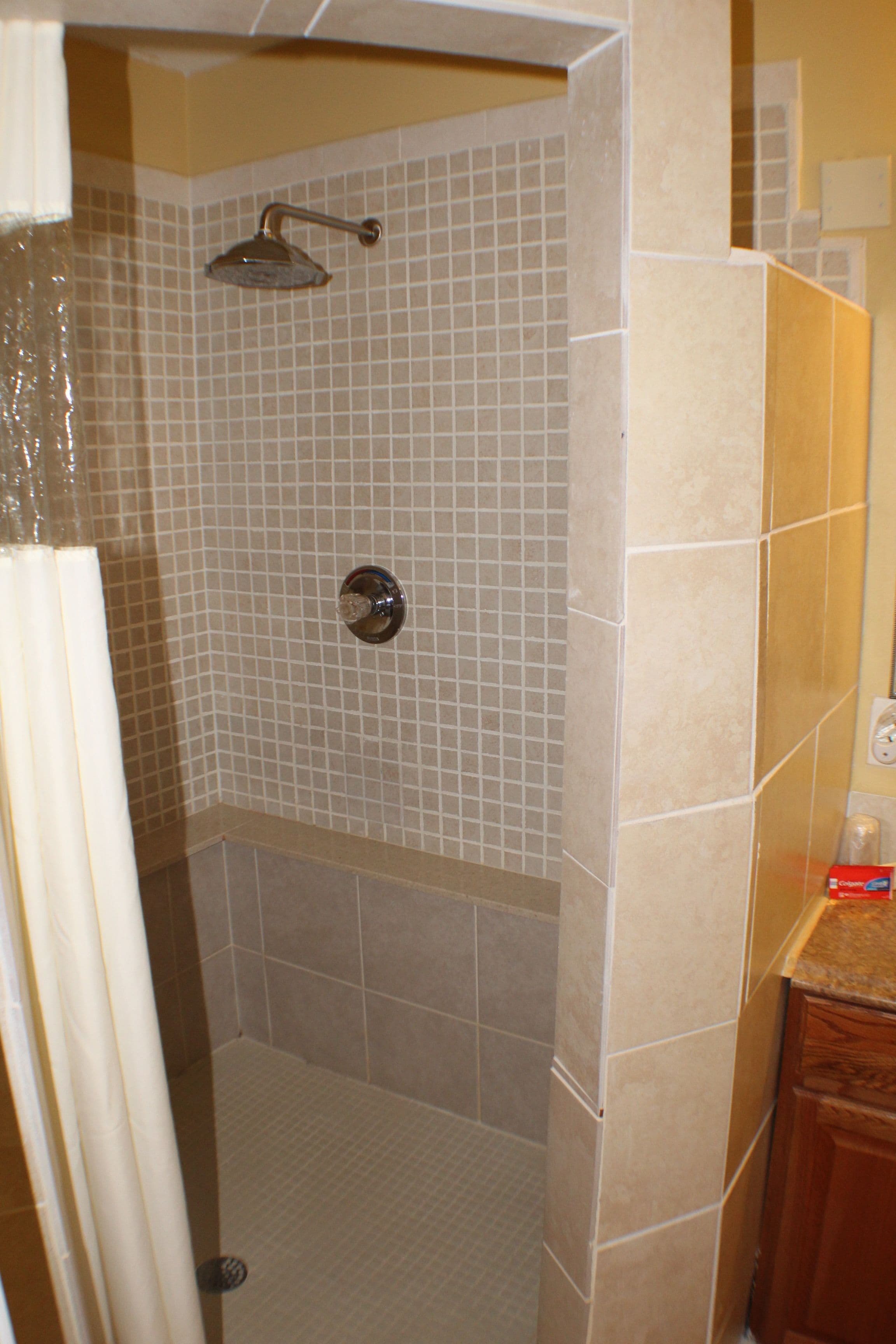 A shower area with tiled walls and a showerhead.
