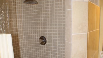 A shower area with tiled walls and a showerhead.