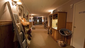 Un couloir d’hôtel avec des murs en bois, un comptoir de réception et un panneau indiquant « Réservé au personnel ».