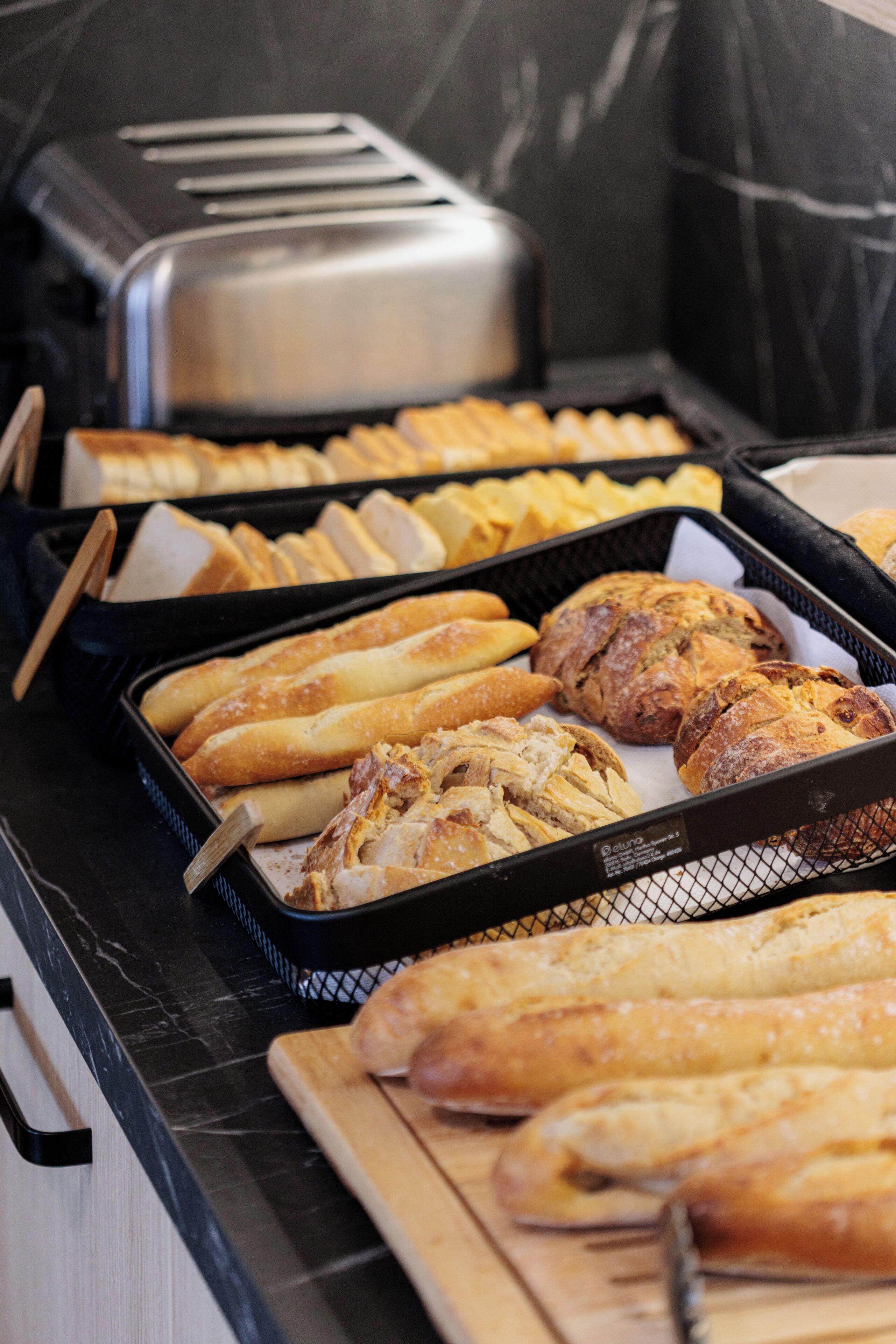 A buffet with various breads and a toaster.