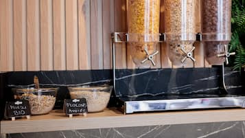 A food dispensing station with labeled containers for Muesli Bio and Flocons Avoine.