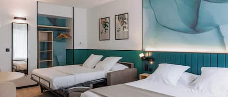 A hotel room with two beds, a desk, a chair, a wardrobe, and a large abstract painting on the wall.