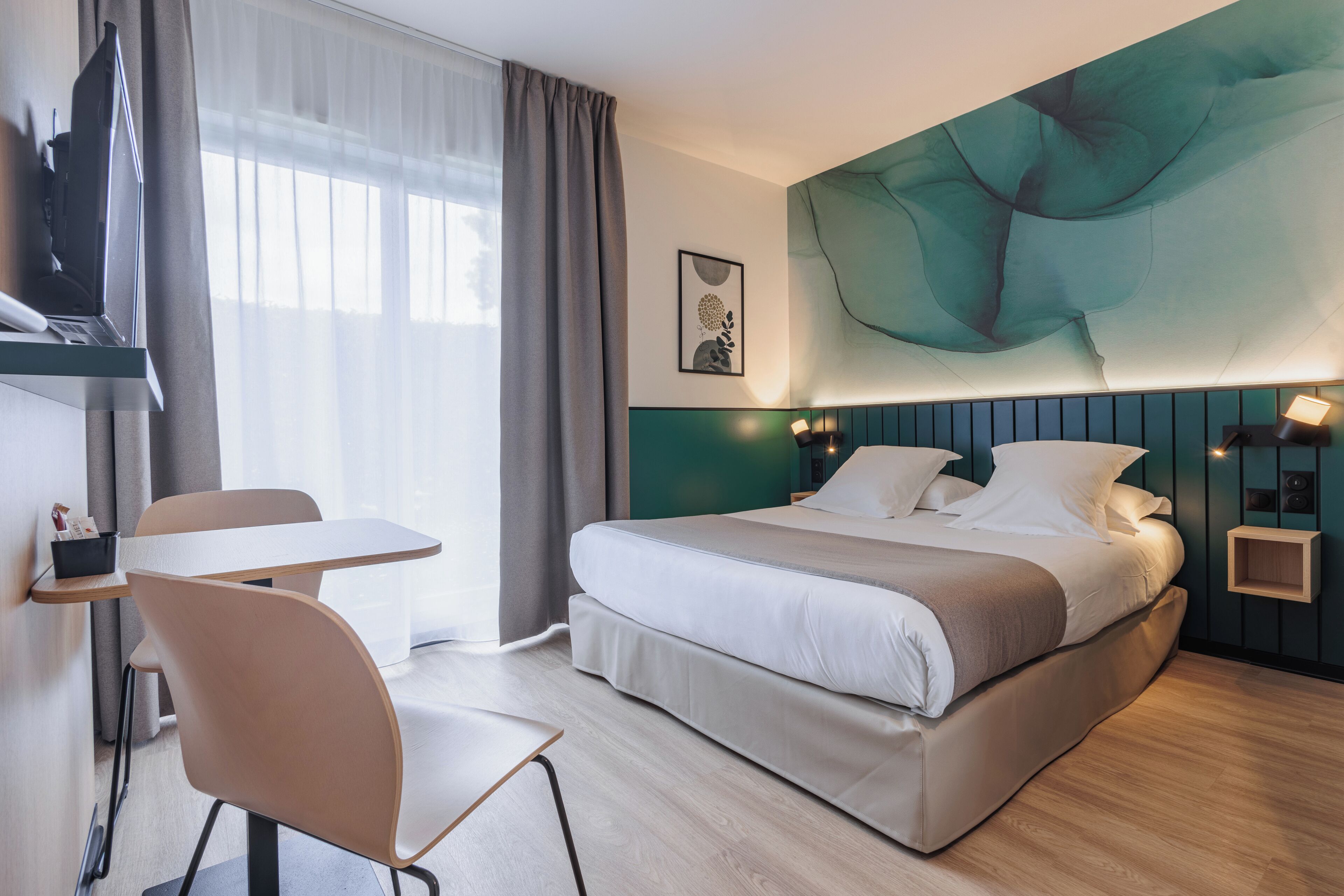 Une chambre d’hôtel moderne, équipée d’un lit, d’un bureau et d’une chaise.