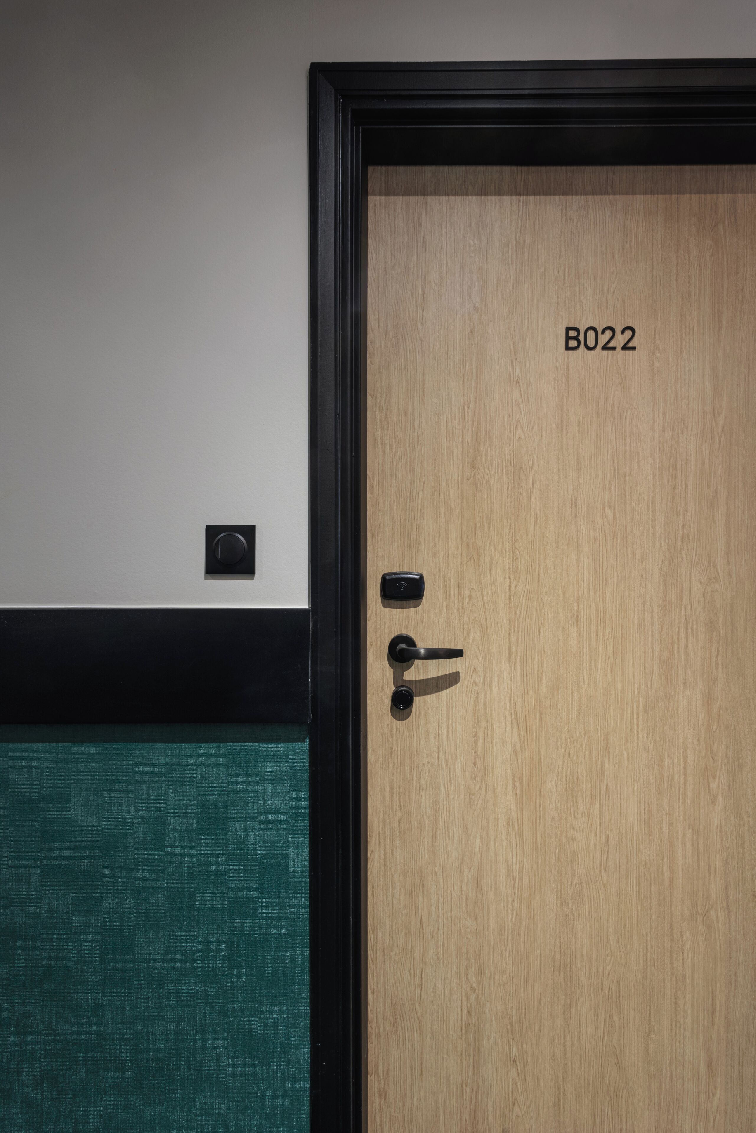 A wooden door with a black frame and a numeric label 'B022'.