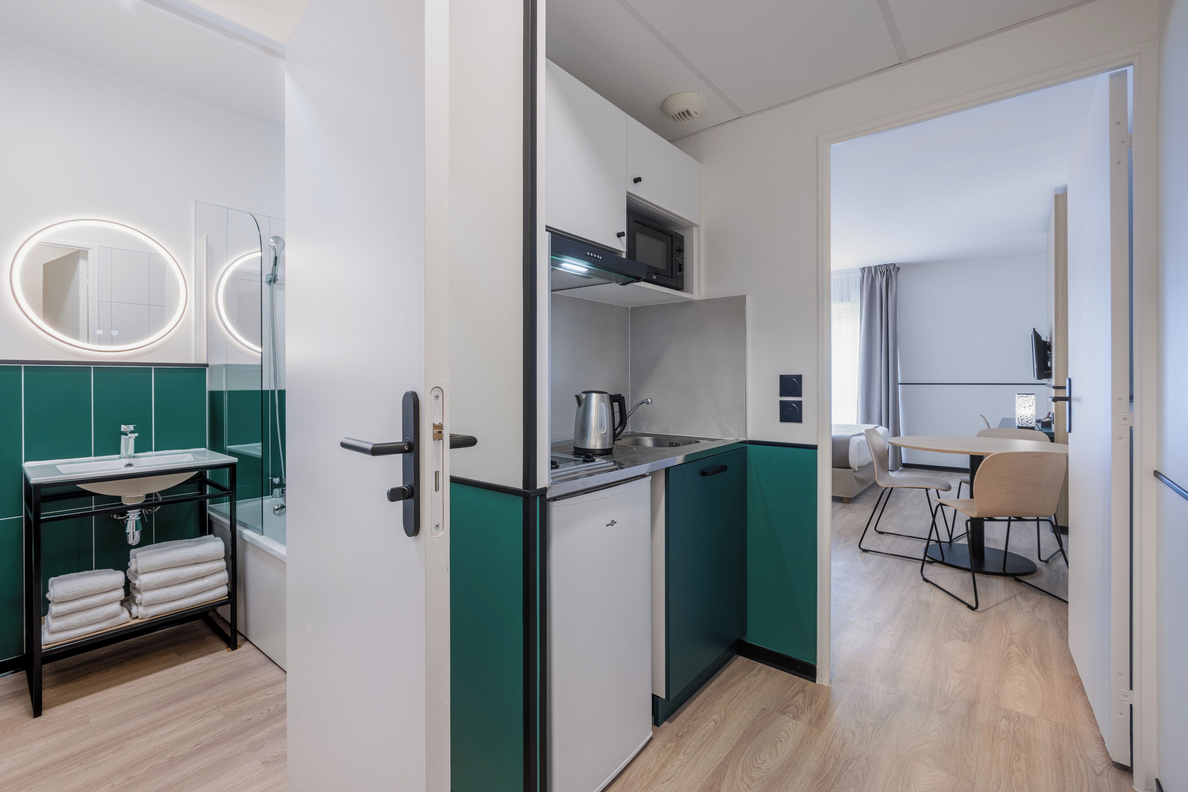A modern kitchen with a built-in microwave, a sink, and a kettle.