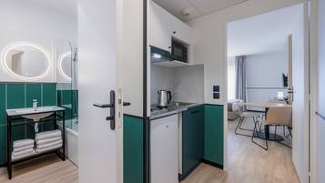 A modern kitchen with a built-in microwave, a sink, and a kettle.