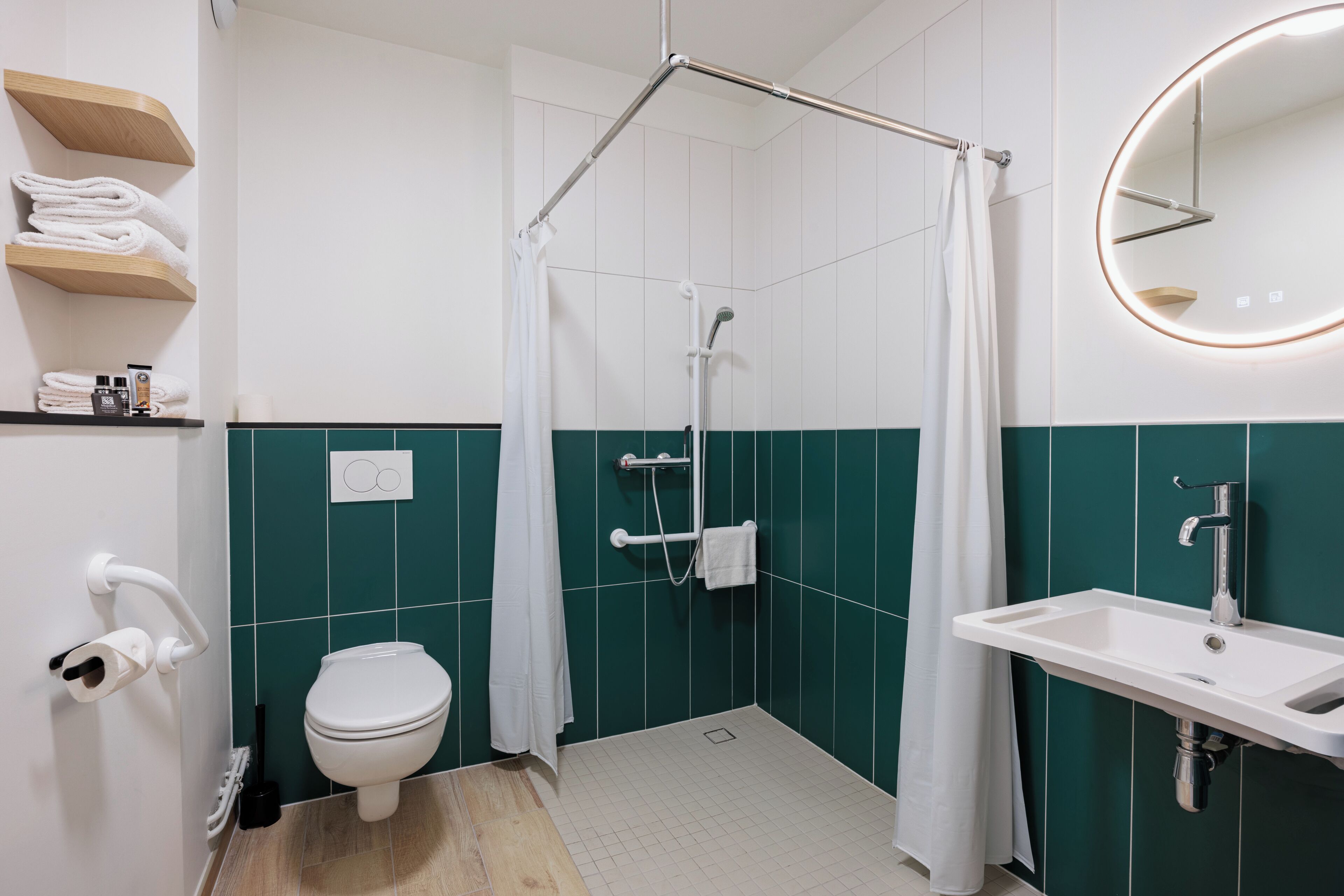 A modern bathroom with a shower, toilet, and sink.