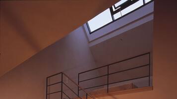 Ein modernes Wohnzimmer mit Treppe, Sofa, Sessel und Lampe.