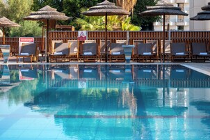 Una piscina al aire libre de temporada, sombrillas, tumbonas
