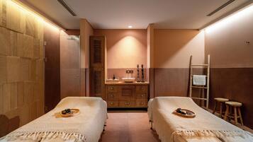 A room with two beds, a wooden cabinet, a sink, and a ladder.