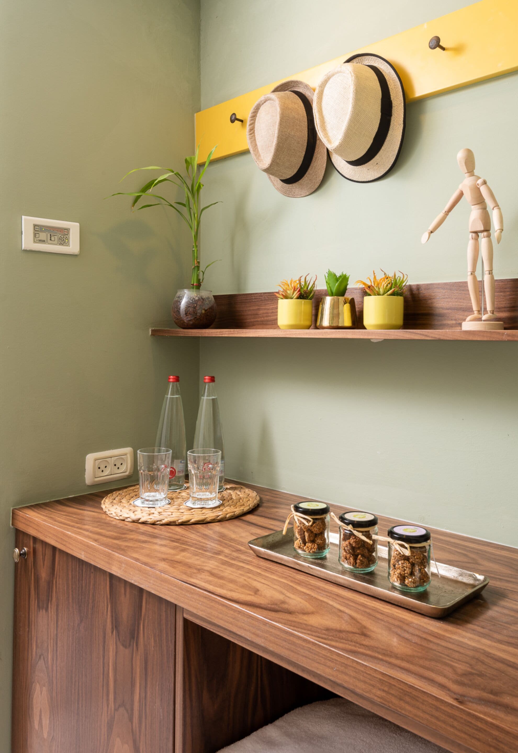 A wooden counter with a woven placemat, two clear bottles, and jars of food.