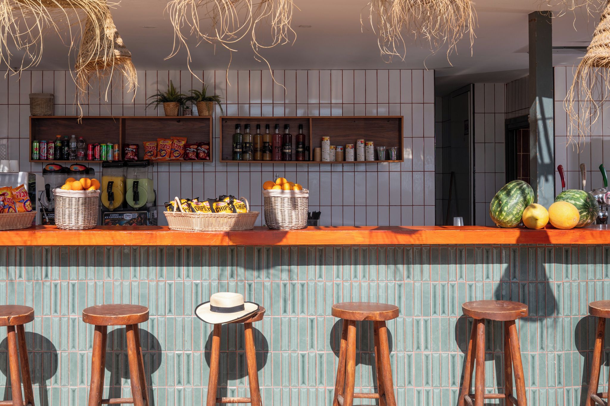 A bar area with stools, a counter with snacks, and a tiled wall.