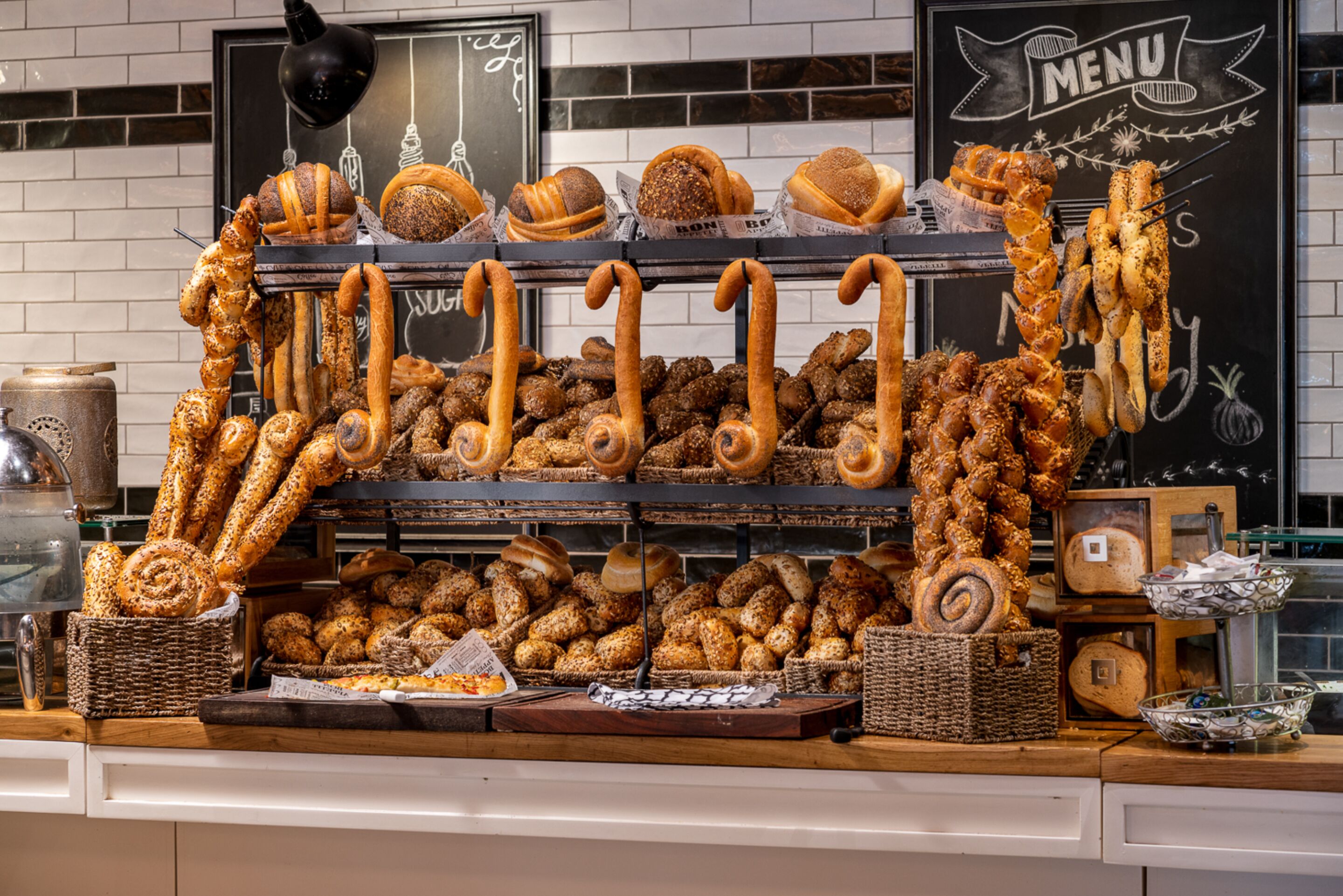 A bakery display with various breads and pastries.