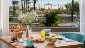 Una mesa de desayuno con vista a la playa y palmeras.
