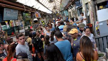 Un mercado concurrido con varios puestos y gente mirando.