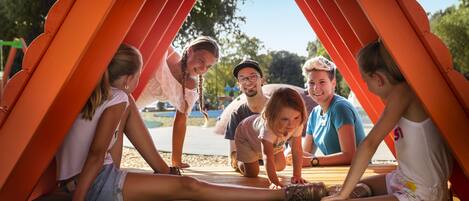 Un grupo de personas sentadas bajo una estructura roja al aire libre.