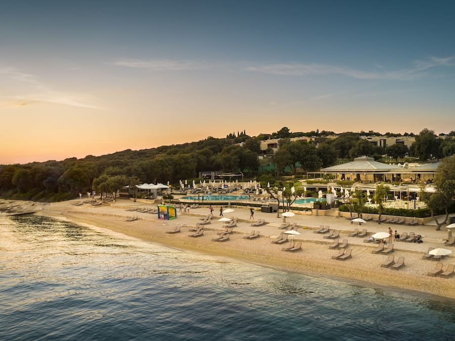 En la playa, sillas reclinables de playa, sombrillas, ski acuático