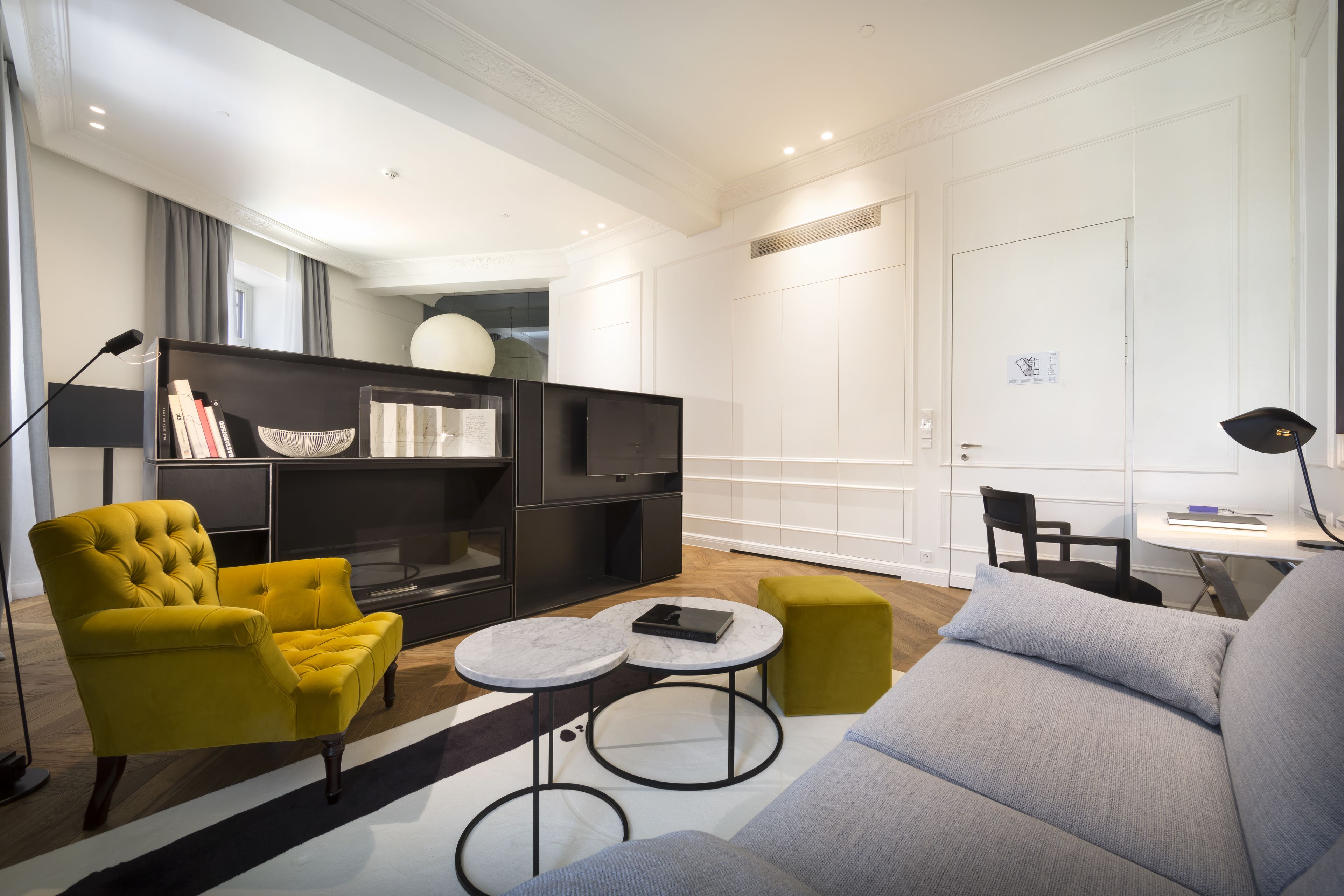 A modern living room with a sofa, armchair, and a round coffee table.