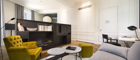 A modern living room with a sofa, armchair, and a round coffee table.