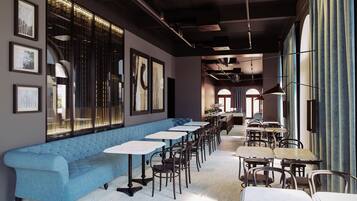Un ristorante moderno con una panca imbottita blu, tavoli bianchi e sedie nere.