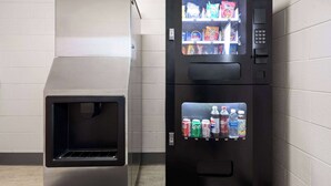 A vending machine with snack and drink options, and a microwave above it. - Super 8 by Wyndham Hazleton (Hazleton)