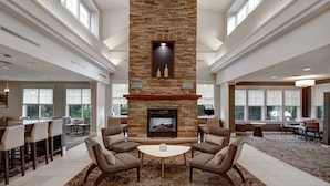 A spacious lobby with a stone fireplace, comfortable seating, and large windows. - Residence Inn by Marriott Morgantown Medical Center Area (Morgantown)
