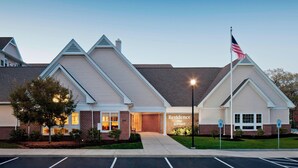 Un hôtel à la façade en briques, avec un drapeau et une enseigne indiquant « Residence Inn Marriott ».
