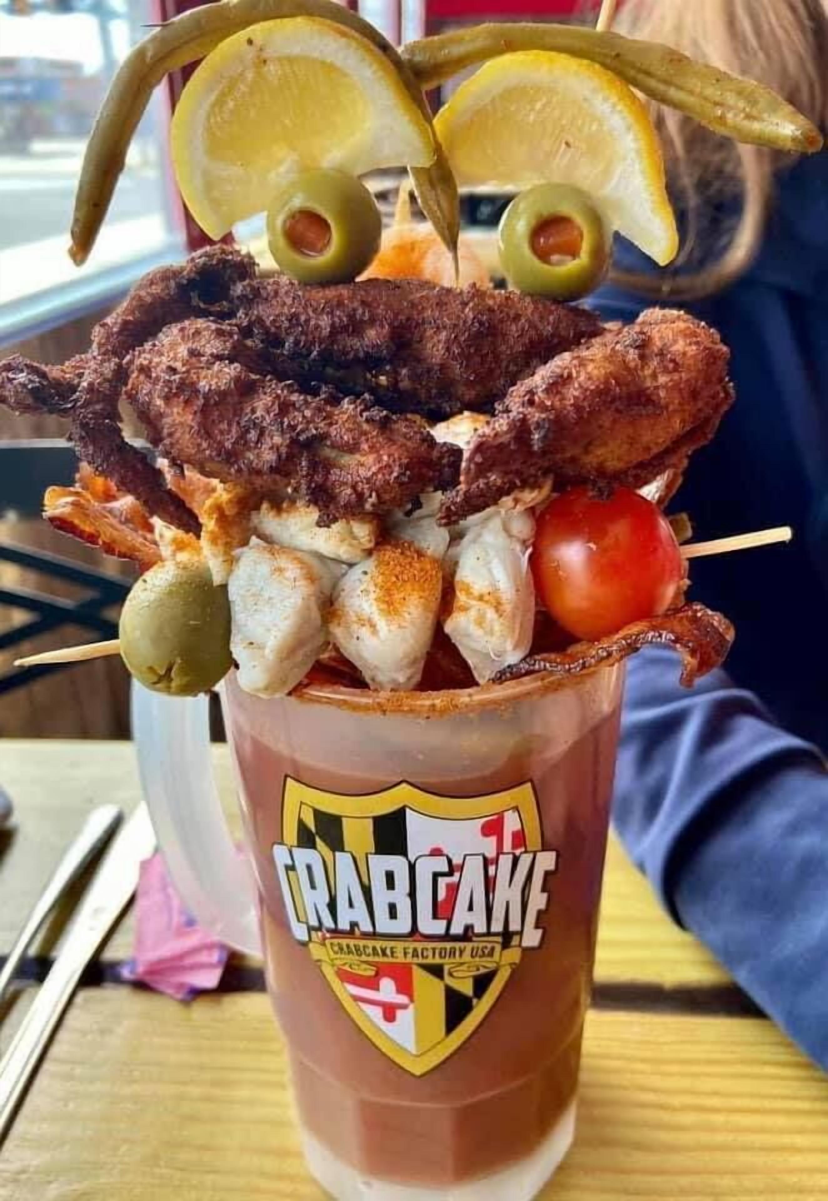 Un vaso de pastel de cangrejo con diversos mariscos por encima.