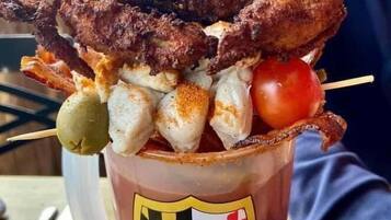 Un vaso de pastel de cangrejo con diversos mariscos por encima.