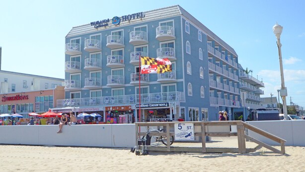 Un hôtel doté de nombreux balcons, situé en bord de mer et dont l’enseigne indique qu’il se trouve dans la 5e rue.