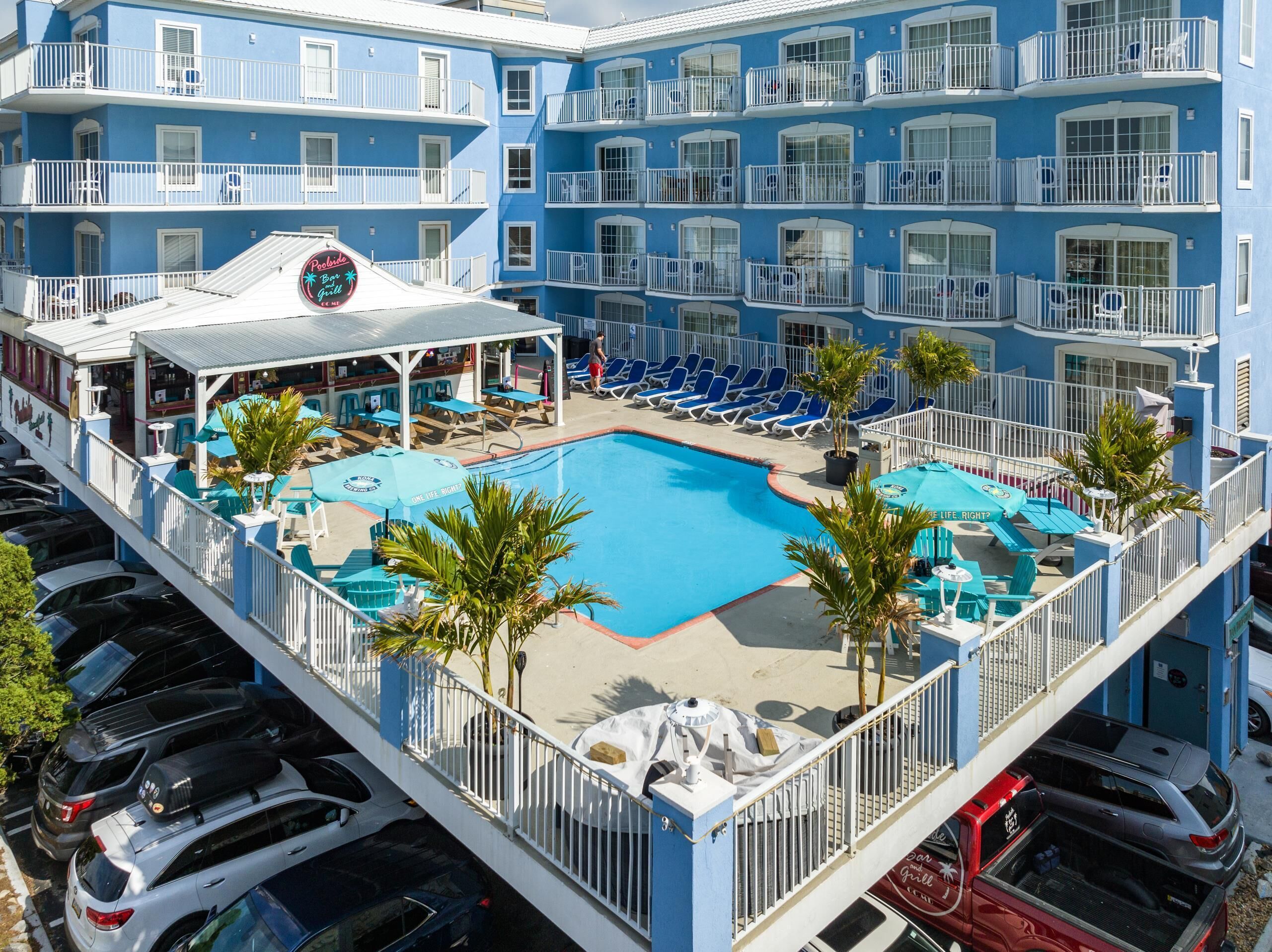 A hotel with a pool area, multiple balconies, and a bar/lounge area.