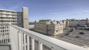A hotel with multiple floors, a prominent tower, and a parking lot with cars.