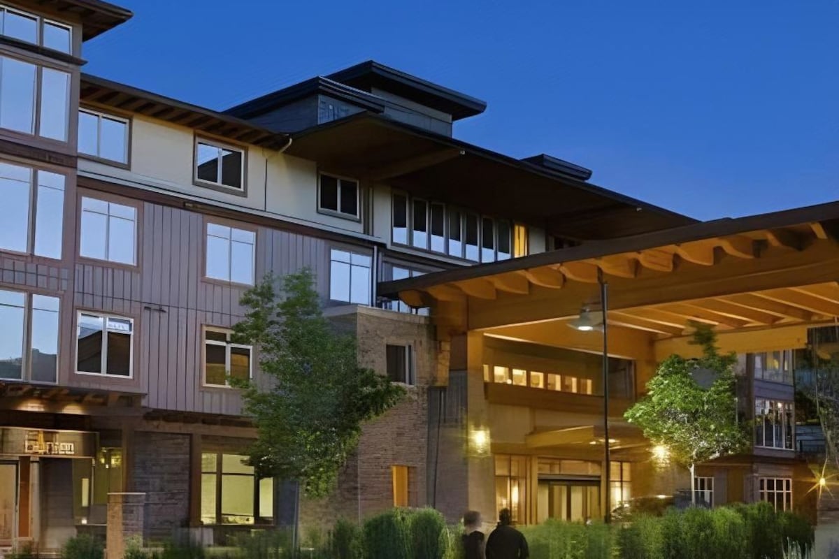 Un hotel de varios pisos con un espacio exterior cubierto y una entrada bien iluminada.