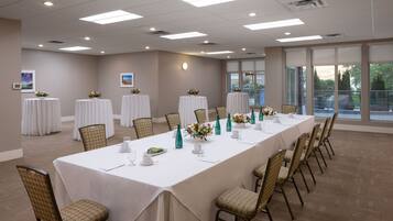 A conference room with a long table, chairs, and floral centerpieces.