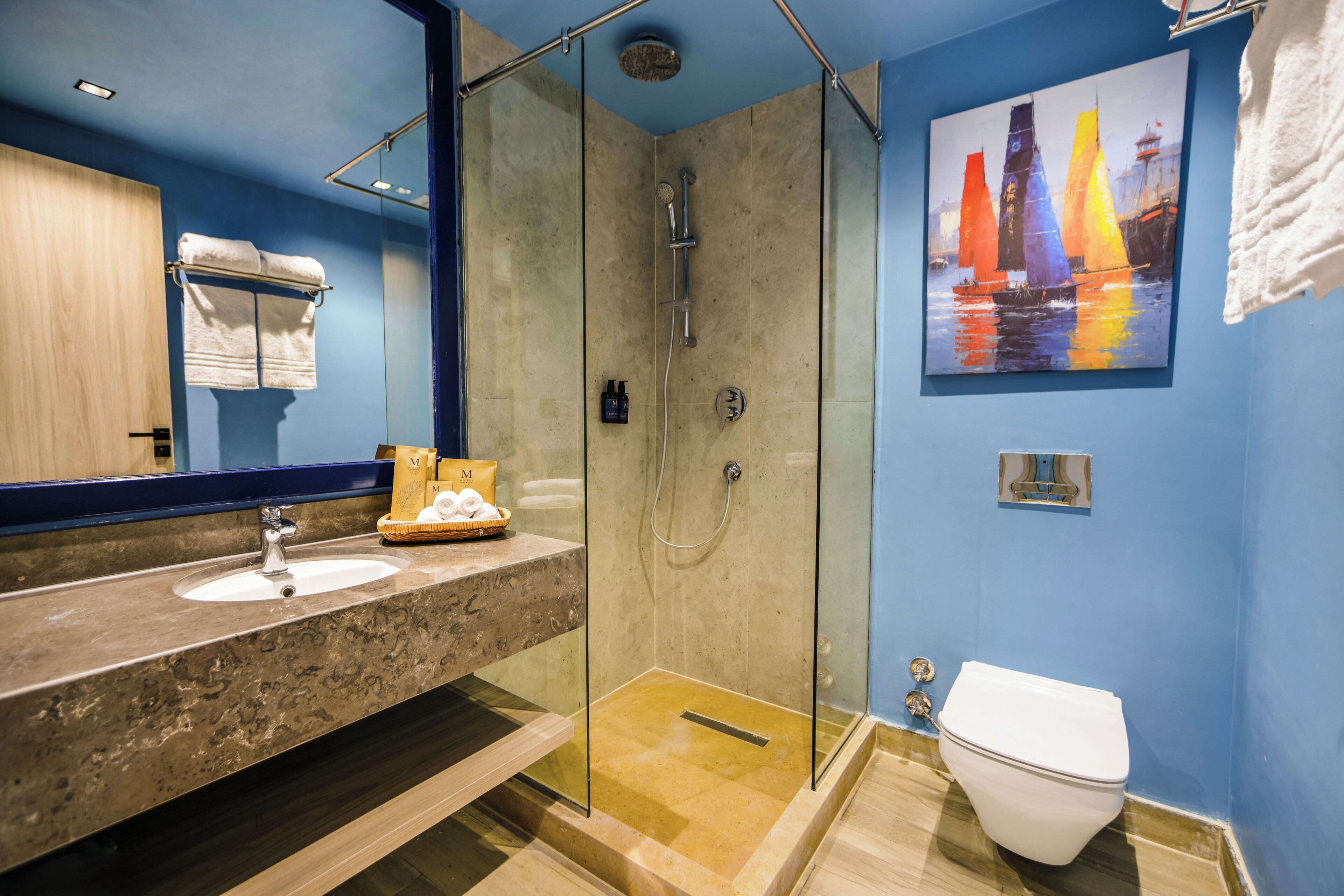 A bathroom with a glass-enclosed shower, a sink, and a toilet.