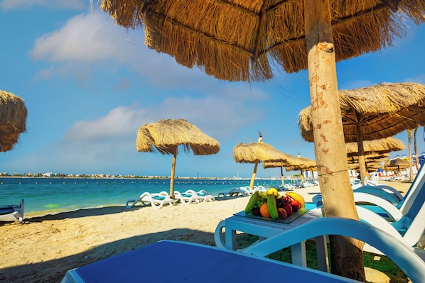 Playa privada, playa de arena blanca y sombrillas