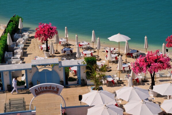 Private beach, white sand, beach umbrellas, motor boating