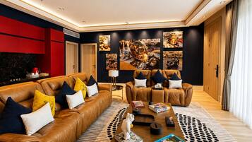 Een moderne woonkamer met leren banken, een salontafel en een muur versierd met motorfiets kunst.