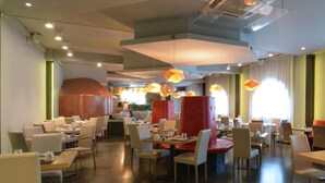 A modern restaurant with high ceilings, recessed lighting, and a mix of booth and table seating. - Due Ragni (Villorba)