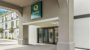 A hotel entrance with a sign reading "Quality Inn & Suites by Choice Hotels."