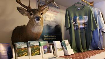 Un présentoir avec une tête de cerf montée, des brochures et un t-shirt.