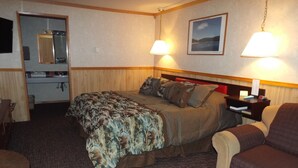 Une chambre d’hôtel équipée d’un lit, d’une chaise, d’un bureau et d’une kitchenette.