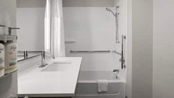 A modern bathroom with a bathtub, a shower, and a vanity with a sink.