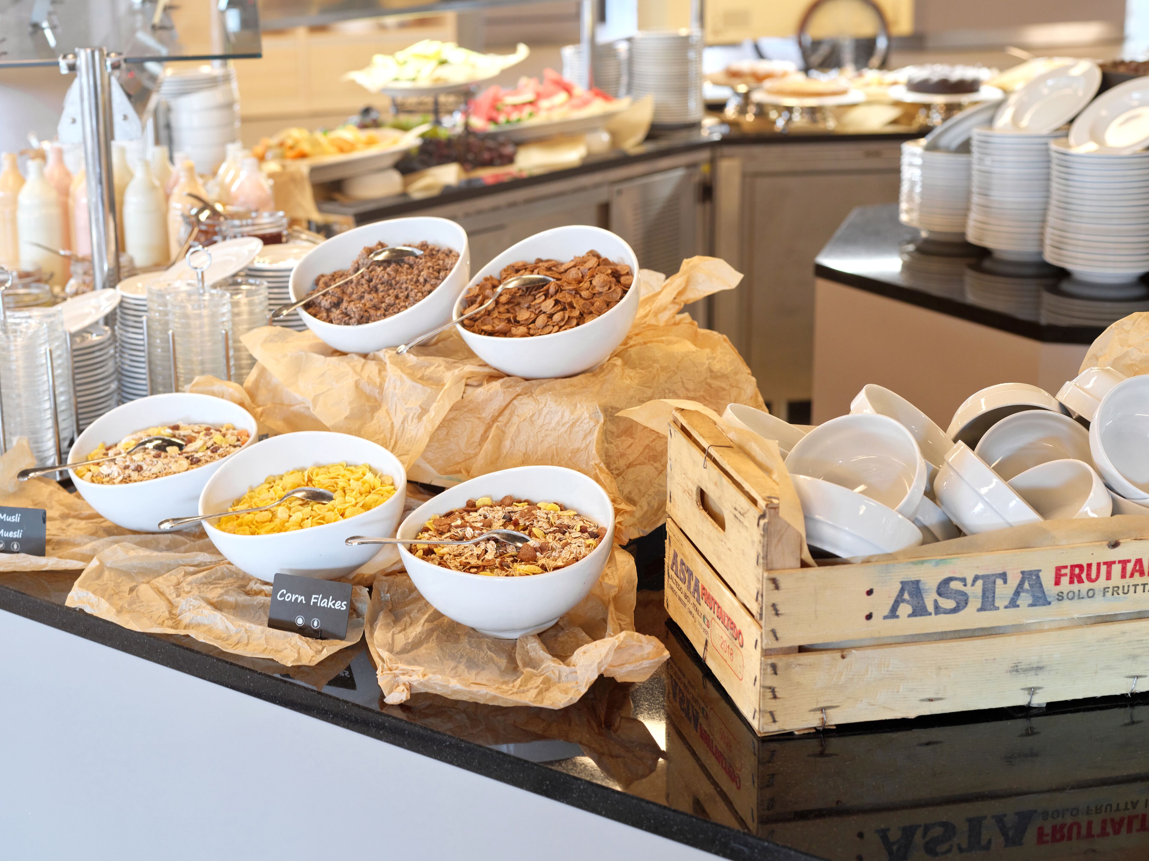 A buffet with various breakfast cereals and fruits.