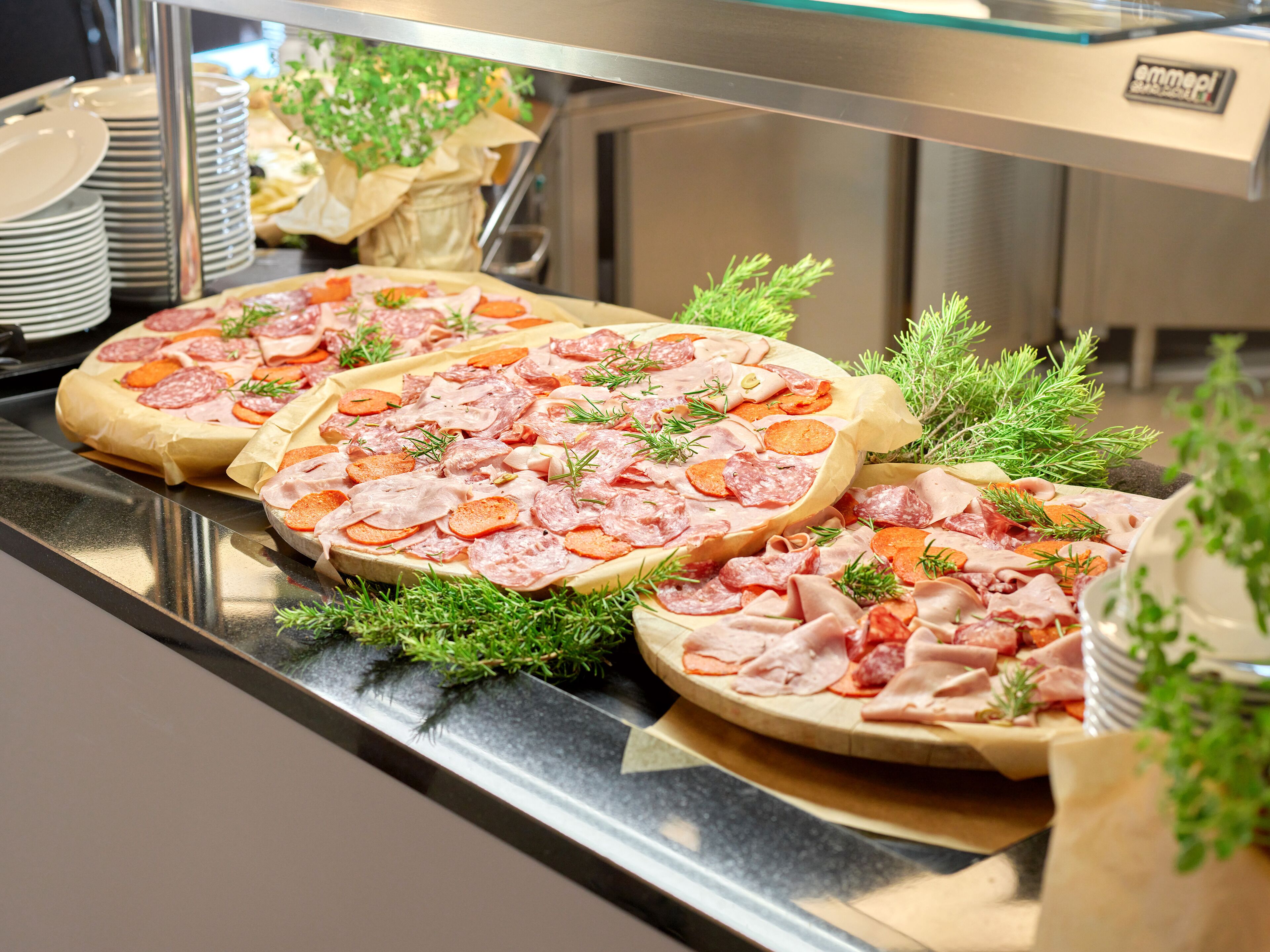 A buffet with various types of meat and cheese arranged on plates.
